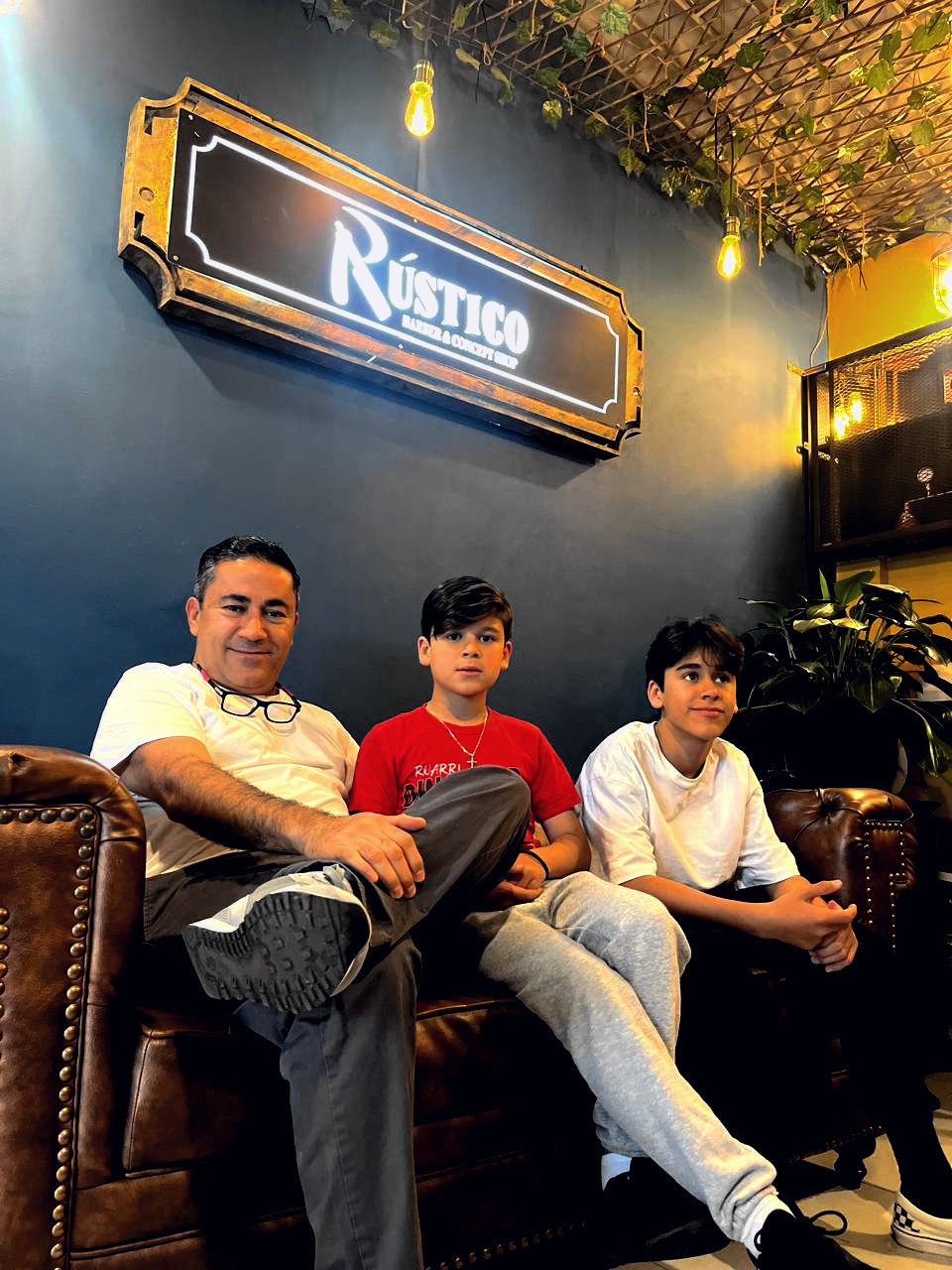 Familia en el sofá Chesterfield de Rústico Barber — ambiente y marca