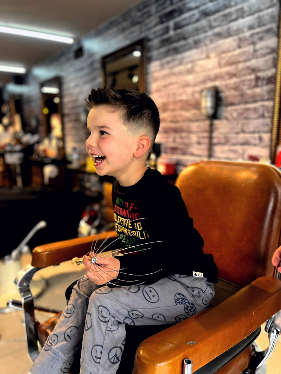 Niño feliz en la silla clásica de Rústico tras su corte