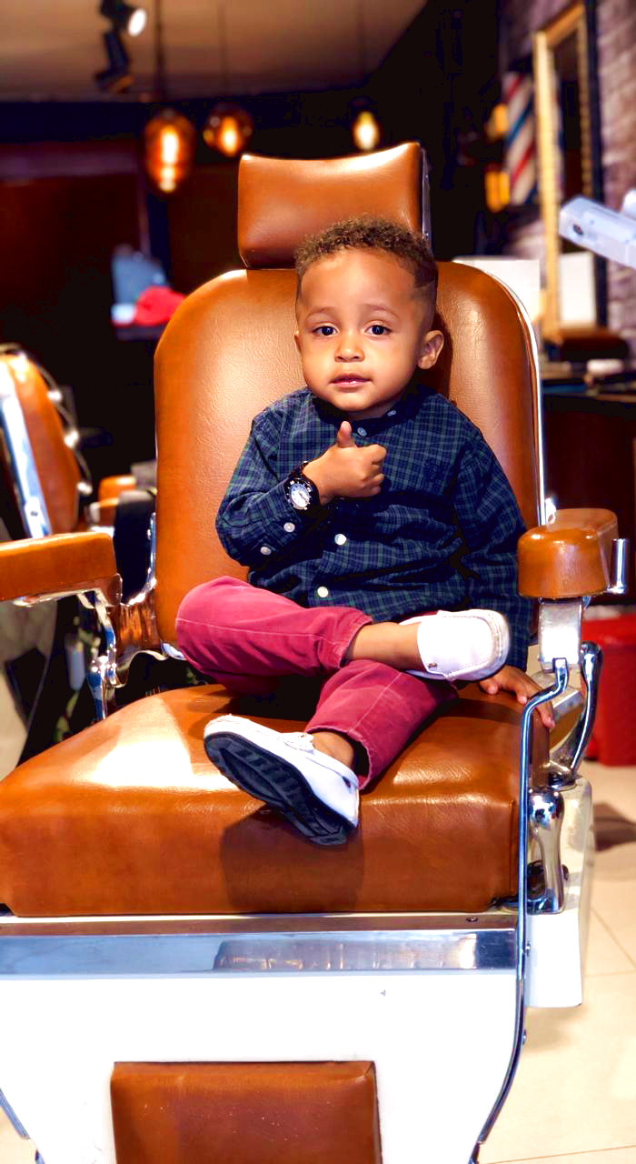Bebé con pulgar arriba en la silla de barbero — Rústico para toda la familia